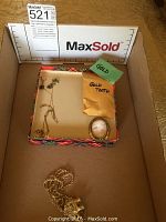 Overview of lot contents: rope chain with elephant pendant, earrings, cameo brooch and gold tooth envelope