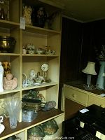 Shelf displaying various collectibles including clocks, glassware, and decorative items.