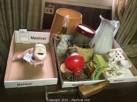 Lot contents showing piggy bank, water pitcher, lighting items, and fan