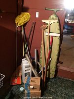 Full view of cleaning tools, ironing board, vacuum cleaner, and accessories grouped together