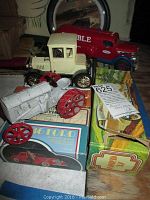 Photo showing cast iron white tractor, cream antique model car, red Humble gas truck, and several vintage Avon aftershave boxes.