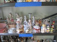 Front view of miniature ceramic figurines including children, animals, and cartoon characters such as Mickey and Minnie Mouse.