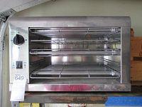 Front view showing two wire racks, stainless steel interior, control knob on left, and two switches below it (likely power and function).