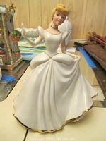 Front view of Lenox Cinderella figurine wearing white dress with gold trim, showing details of face and gown folds.