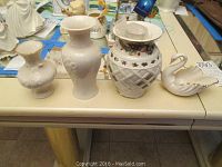 Four Lenox porcelain items on table: three vases and one swan basket shown from above.