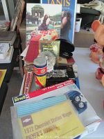 Photo showing boxed Revell '37 Ford Convertible with Trailer model kit, Corgi Guinness Truck, Kings Cobra car shield in case, kaleidoscope, and other items arranged on table.