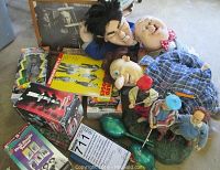 Three Stooges dolls in various clothing, VHS and DVD sets, framed photograph, animated golf-themed display figurine, book