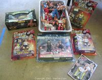 Overview of loose and packaged wrestling figures laid on floor and in metal tray