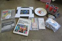 Several World's Fairs memorabilia items arranged including souvenir books, maps, glasses, trays, tickets, and a plate.