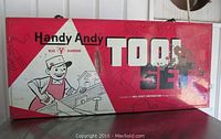 Closed red metal toolbox with Handy Andy cartoon logo and tool set label.