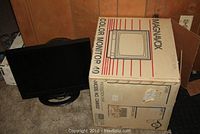 Magnavox color monitor next to original box with striped design and model information visible.
