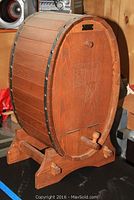 Closed view of wooden barrel bar front with carved inked door and wood base