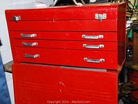Exterior view of the large red metal tool box showing multiple drawers and metal handles.