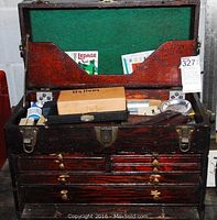 Wooden toolbox open showing top compartment with green felt lining and assorted tools