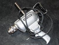 Older Craftsman hammer drill resting on black surface.