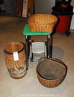 Overview of entire lot showing the wooden barrel, two baskets, and metal stool on concrete floor.