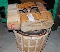 Overhead photo showing one large bushel basket and two smaller 4 quart wooden baskets stacked together with a lot tag.