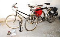 Two bicycles side by side with pump and accessories arranged