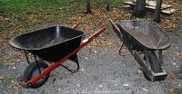 Overview of both wheelbarrows side by side on gravel and grass