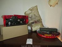 1953 Mira Chevrolet pickup model in original box, Plasticville pieces behind, Schaefer branded red metal tray holding assorted train cars and small toys.