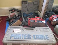 Porter Cable carrying case and parts of several tools including circular saw and belt sander visible