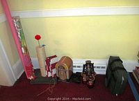 Photo showing cat scratching tower, decorative jukebox tin, Micronta binoculars, four battery operated lanterns, and green Victor carrying case for emergency kit.