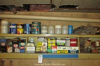 Multiple shelves of assorted hardware including labeled boxes of finish nails, specialty nails, and screws organized in bins and cans