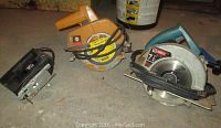 Photo showing all three power tools on a concrete floor: Black and Decker orange 7-1/4 inch circular saw, Ryobi blue 7-1/2 inch circular saw, and Black and Decker jig saw with cord.