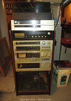 Stereo rack system view showing the full unit with stacked components including turntables and 8-track player.
