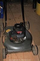 Full view of the Craftsman push lawnmower showing metal cutting deck, wheels, handle, and engine cover.