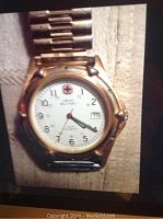 Front view of Swiss Military wristwatch showing white dial with Arabic numerals, red Swiss cross logo, and metal bracelet.