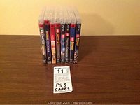 Photo shows 8 PS3 game cases lined up with a MaxSold tag indicating lot 11 titled 'PS3 Games'.