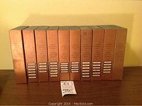 Ten copper-toned boxed volumes of the American Geographical Society Around the World Program by Double Day, neatly lined up side by side.