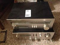 View of the Hitachi stereo amplifier and tuner stacked, showing front panels and controls.