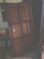 Front view of bifold door panels showing carved details and riveted studs