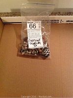 Photo of sealed bag containing an assortment of costume jewelry including rings, bracelets, and earrings.