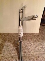 Front view of the Delta stainless steel kitchen faucet showing the handle, spout, and label attached to the body.