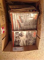 Box filled with over 50 vintage QST Amateur Radio magazines stacked upright and showing front covers of some issues on top