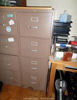 Front view of the four-drawer Hon metal file cabinet showing rust at the bottom and condition details.