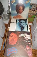 Photo showing three vinyl record covers with diverse artwork and portraits depicting pop, rock and soul albums.