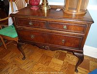 Front view of solid wood server showing drawer hardware, finish wear, and carved legs.