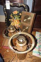 Two vintage wooden pitcher-shaped lamps with metal rings, hand-painted tole tray with floral pattern, and wooden weather station with barometer and thermometer placed on floor boxes.
