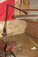 Workbench with vintage Craftsman vise mounted and a brown adjustable swing arm work light above it.
