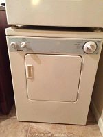 Front view of a compact off-white Kenmore front load dryer showing its control panel and front door.