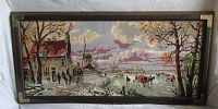 Full view of the framed needlepoint showing a country scene including houses, a road, horses, people and a windmill.