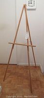 Full view of oak tripod easel standing upright showing height and wood finish.