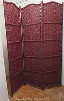 Three-panel burgundy fiber weave room divider fully extended and standing upright.