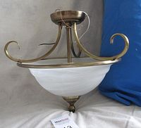 Side view of ceiling light showing opaque glass dome, burnished brass frame with three curled arms, and wiring.