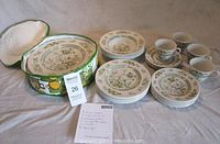 Full set of Royal Doulton Tonkin design china including plates, bowls, tea cups and saucers arranged with original metal tin