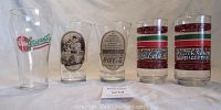 Photo showing front view of 5 Coca-Cola collector glasses in a row on a white background.